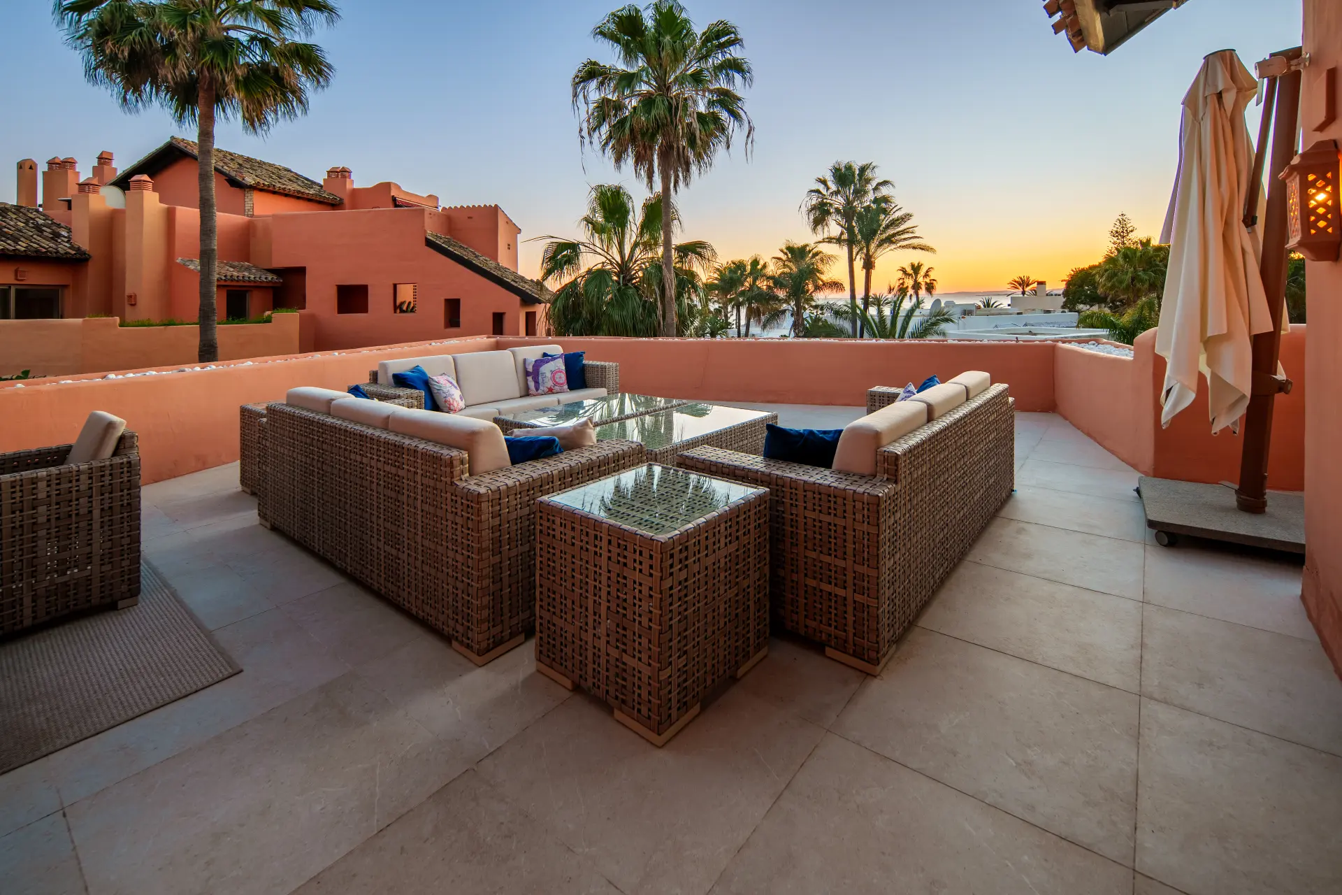 Beachfront terrace at sunset with palm trees in La Morera, Marbella East